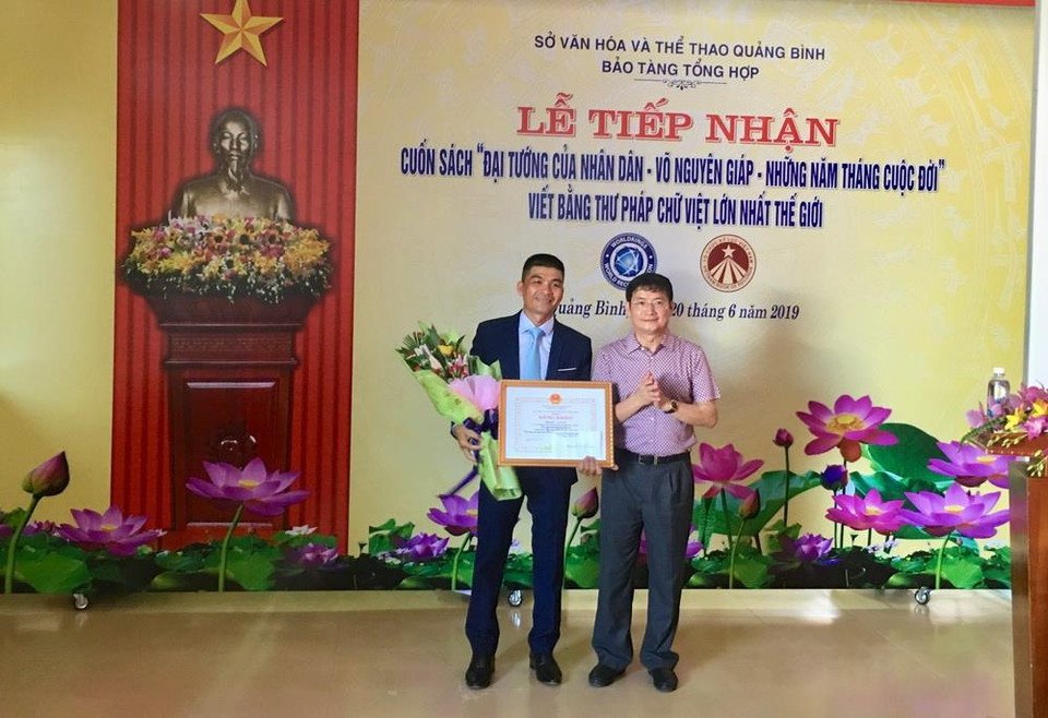 Phó Chủ tịch UBND tỉnh Quảng Bình Trần Tiến Dũng trao tặng Bằng khen của Chủ tịch UBND tỉnh Quảng Bình cho tác giả Võ Dương. (Ảnh: Võ Dung/TTXVN)