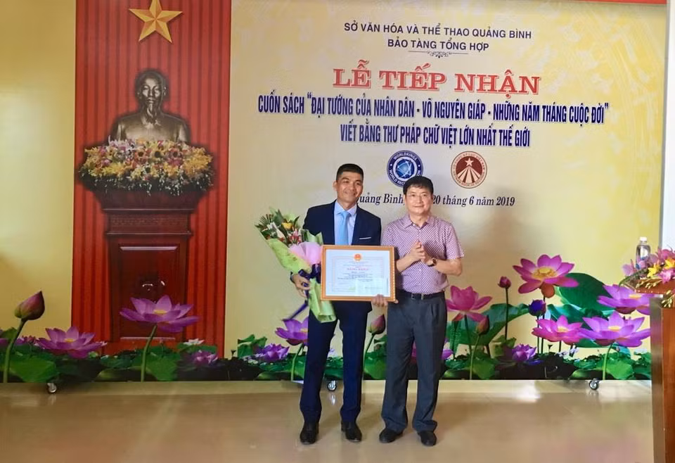 Phó Chủ tịch UBND tỉnh Quảng Bình Trần Tiến Dũng trao tặng Bằng khen của Chủ tịch UBND tỉnh Quảng Bình cho tác giả Võ Dương. (Ảnh: Võ Dung/TTXVN)