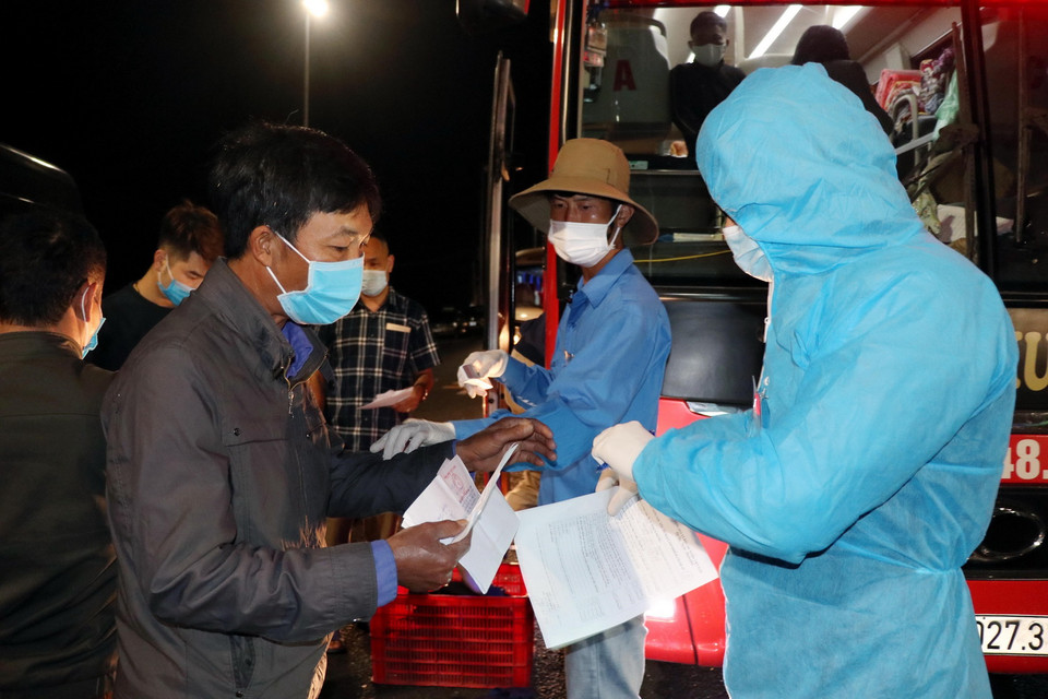 Tất cả các hành khách cùng lái xe, phụ xe đều phải thực hiện việc khai báo y tế, đo thân nhiệt trước khi ra, vào Quảng Ninh. (Ảnh: Văn Đức/TTXVN)