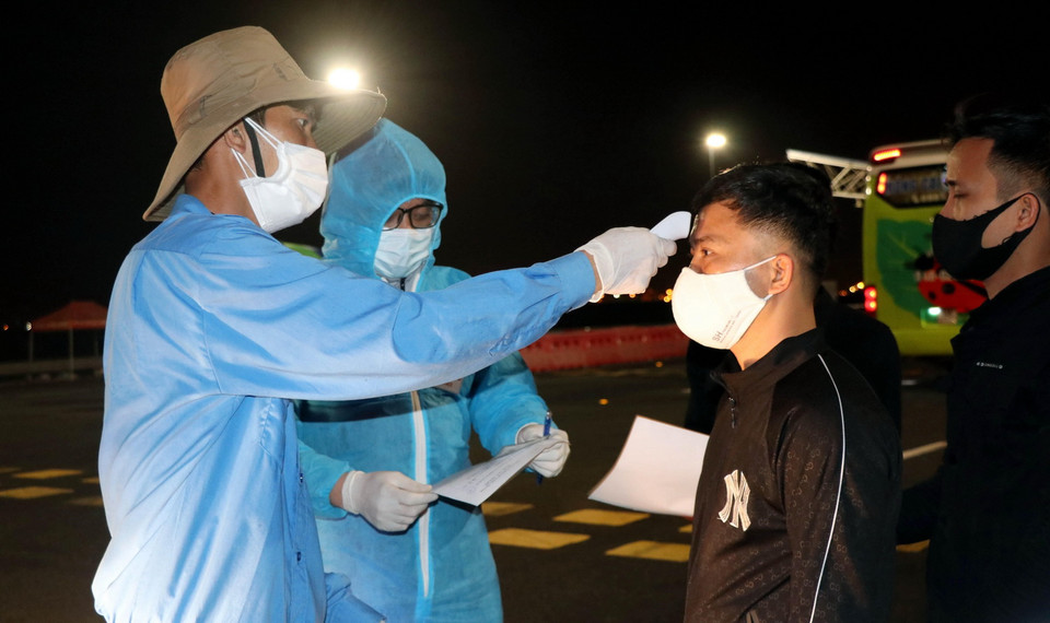 Tất cả các hành khách cùng lái xe, phụ xe đều phải thực hiện việc khai báo y tế, đo thân nhiệt trước khi ra, vào Quảng Ninh. (Ảnh: Văn Đức/TTXVN)