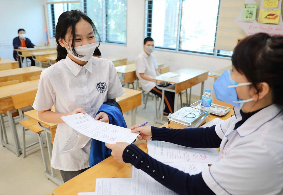 Học sinh lớp 9 trường THCS Kim Giang, quận Thanh Xuân nhận giấy chứng nhận tiêm chủng. (Ảnh: Thanh Tùng/TTXVN)