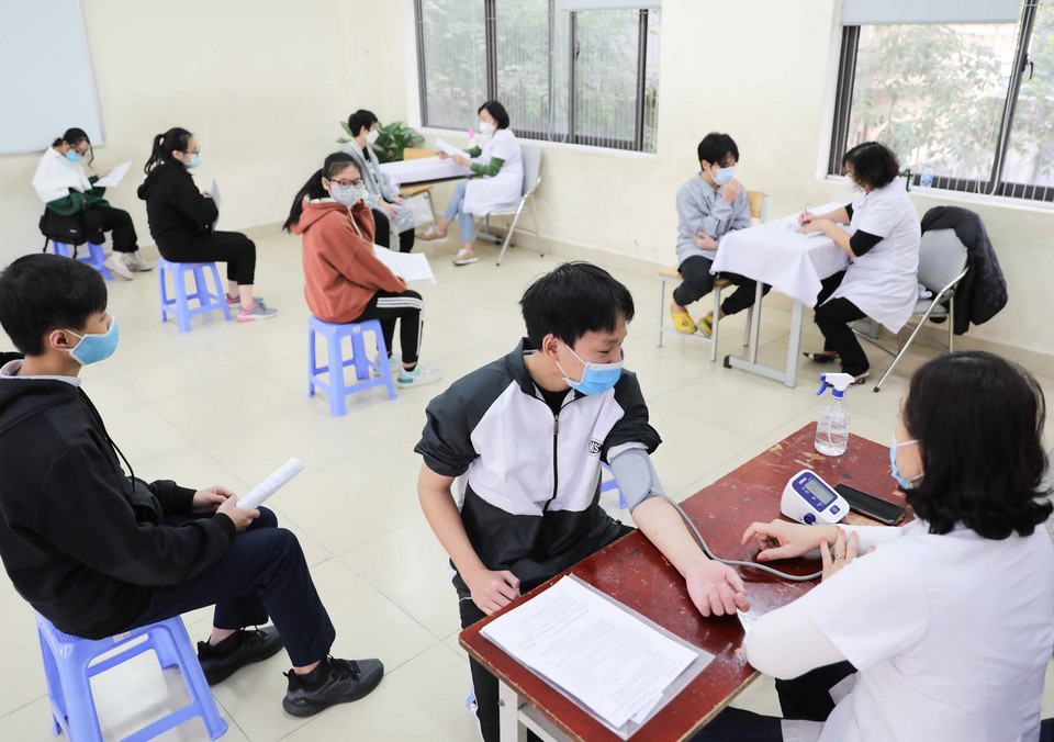 Tất cả học sinh khi đến tiêm đều được kiểm tra sức khỏe, tư vấn về các phản ứng sau tiêm. (Ảnh: Thanh Tùng/TTXVN)