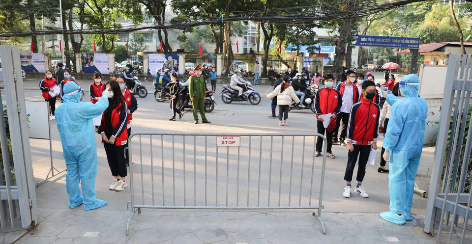 Học sinh tới điểm tiêm Trường THCS Khương Đình, quận Thanh Xuân được đo thân nhiệt, sát khuẩn tay. (Ảnh: Thanh Tùng/TTXVN)