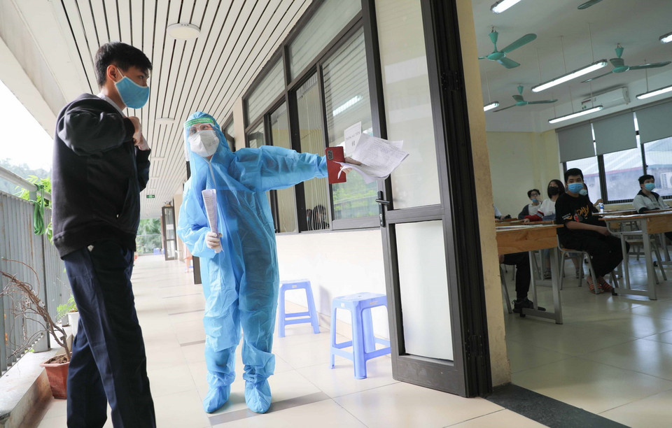 Hướng dẫn học sinh vào phòng chờ sau tiêm tại điểm tiêm Trường THCS Khương Đình, quận Thanh Xuân. (Ảnh: Thanh Tùng/TTXVN)