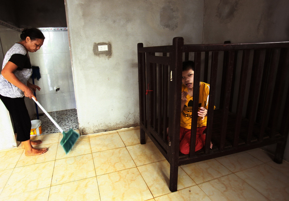 Chị Lại Thị Hà (phải, sinh 1983, tại thôn Tân Hương, xã Phúc Thành, huyện Vũ Thư) với mẹ là bà Quảng Thị Ngoãn (sinh 1961). Chị Hà mắc chứng tâm thần bẩm sinh, lớn lên hoàn toàn trong chiếc cũi gỗ. Bố chị Hà là ông Lại Văn Hằng (sinh 1953) chịu ảnh hưởng chất độc da cam/dioxin khi tham gia lực lượng pháo binh tại chiến trường Nam Bộ đầu năm 1975. (Ảnh: Lâm Khánh/TTXVN)