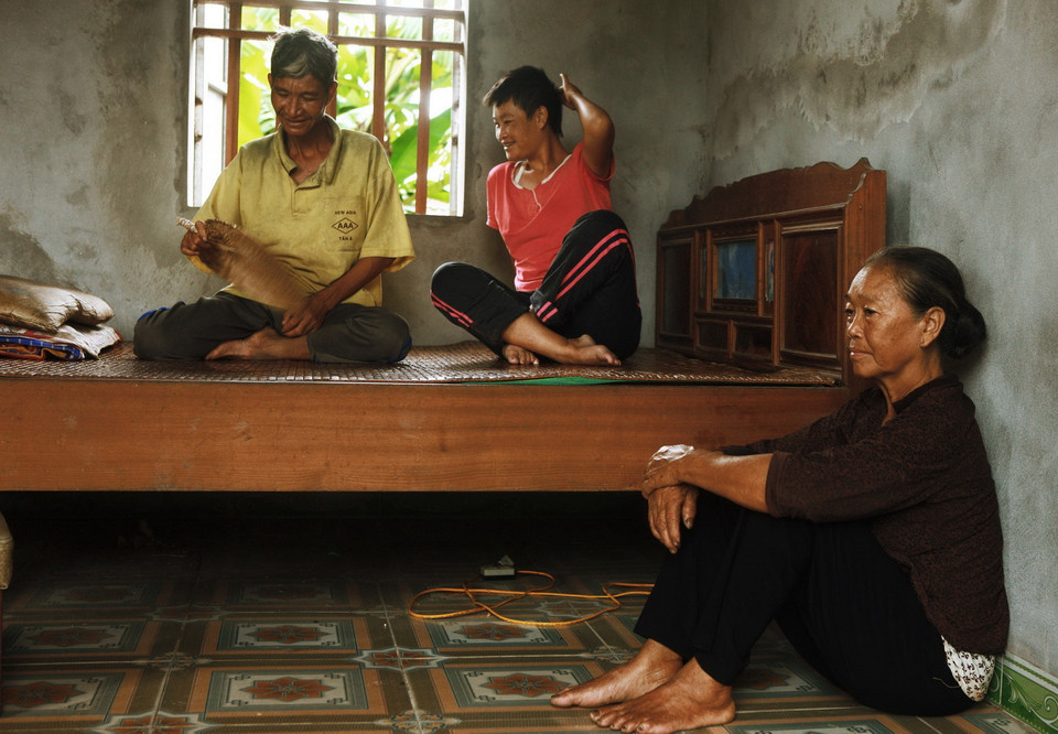 Bà Bùi Thị Mậu (sinh 1944) bên cạnh hai con là anh Bùi Văn Vang (sinh 1975) và chị Bùi Thị Nguyệt (sinh 1983) tại thôn Hưng Đạo Tây, xã Đông Quang, huyện Đông Hưng. Cả anh Vang và chị Nguyệt đều bị tâm thần bẩm sinh do ảnh hưởng chất độ da cam/dioxin từ bố là ông Bùi Văn Ơn (sinh 1942, mất 2002). Ông bà có 4 người con thì cả 4 người đều nhiễm chất độc da cam/dioxin (1 người đã mất, 1 người bỏ nhà đi). (Ảnh: Lâm Khánh/TTXVN)