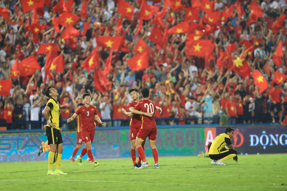 Niềm vui của cầu thủ U23 Việt Nam và người hâm mộ sau khi vượt qua U23 Malaysia ở trận bán kết. (Ảnh: TTXVN)