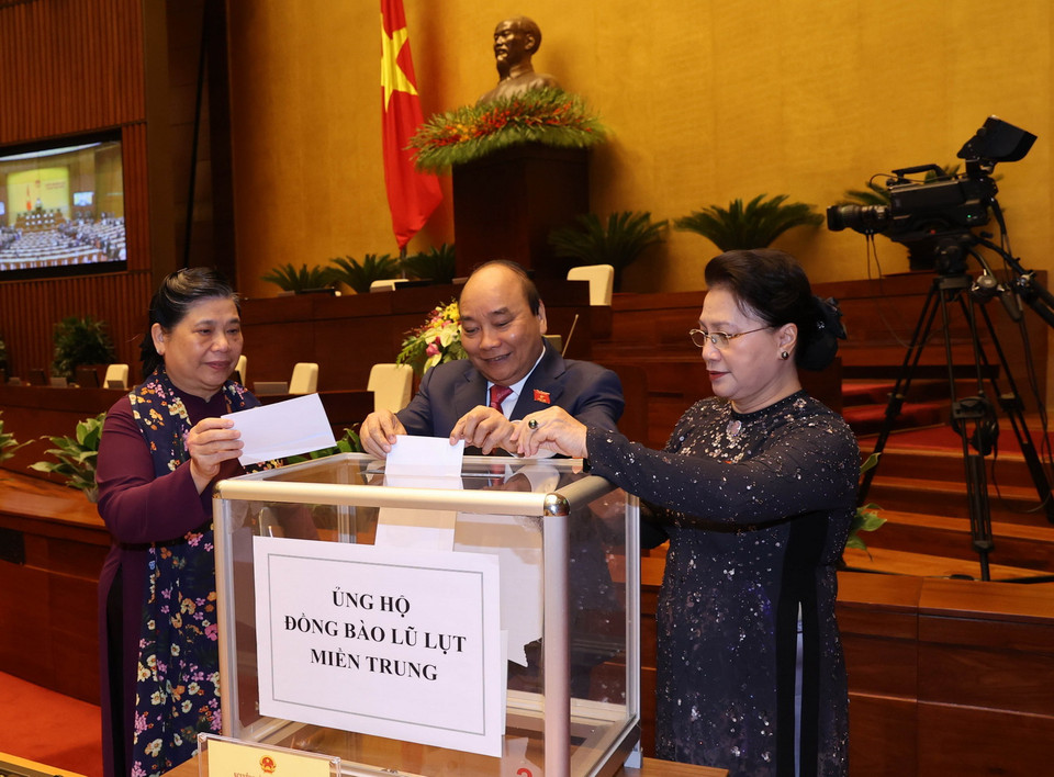 Trong ảnh: Chủ tịch Quốc hội Nguyễn Thị Kim Ngân, Thủ tướng Nguyễn Xuân Phúc và các đại biểu Quốc hội quyên góp ủng hộ đồng bào miền Trung khắc phục hậu quả lũ lụt. (Ảnh: Trọng Đức/TTXVN)