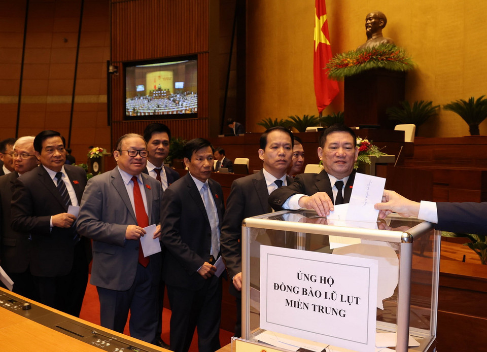 Các đại biểu Quốc hội quyên góp ủng hộ đồng bào miền Trung khắc phục hậu quả lũ lụt. (Ảnh: Trọng Đức/TTXVN)