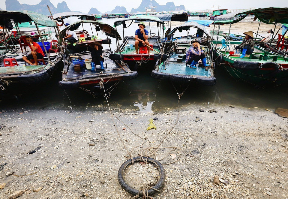Những lái thuyền chờ để đưa hàng hóa về các lán bè và tàu trên biển. (Ảnh: Lâm Khánh/TTXVN)