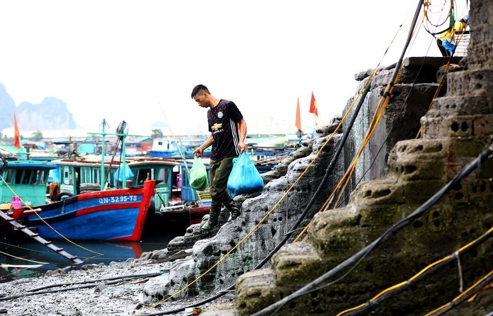 Một ngư dân mua các nhu yếu phẩm phục vụ cuộc sống trên biển. (Ảnh: Lâm Khánh/TTXVN)