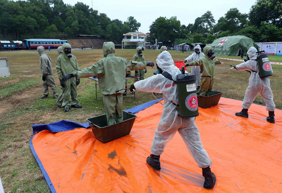 Các lực lượng diễn tập tắm rửa bằng dung dịch tẩy xạ chuyên dụng cho người sau khi ra khỏi vùng nguy hiểm. (Ảnh: An Đăng/TTXVN)