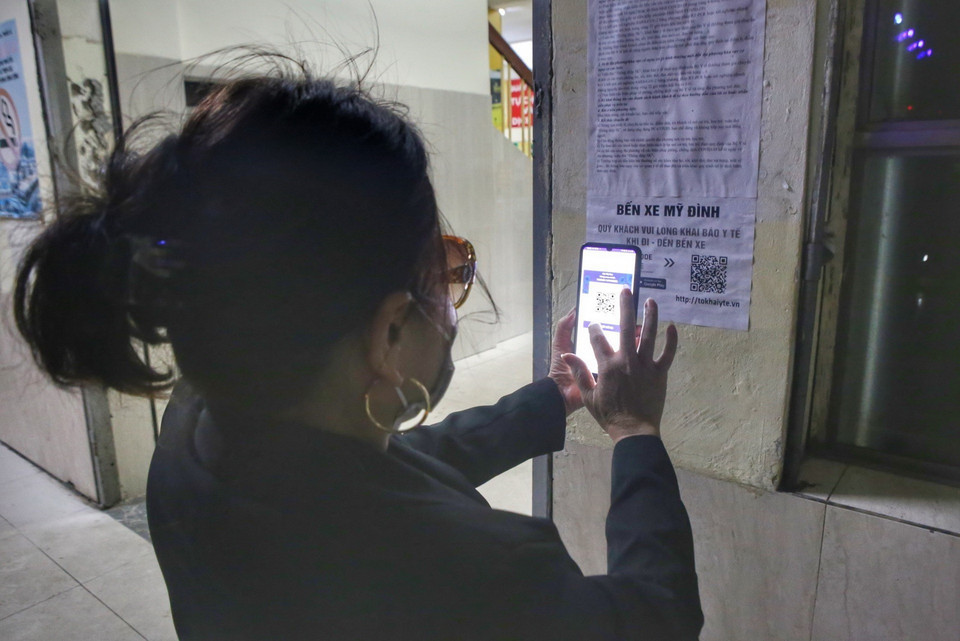 Hành khách quét mã QR trước khi lên xe. (Ảnh: Tuấn Đức/TTXVN)