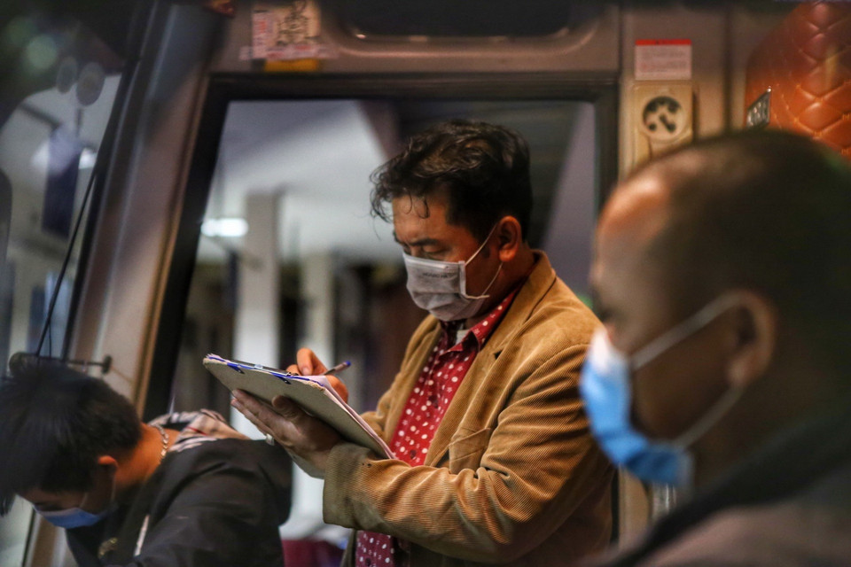 Lái xe Trần Tuấn Anh xem lại danh sách hành khách lần cuối trước khi khởi hành. (Ảnh: Tuấn Đức/TTXVN)