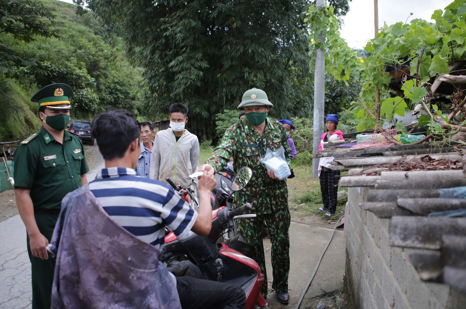  Cán bộ chiến sỹ Đồn Biên phòng Sì Lở Lầu tuyên truyền người dân khi tham gia giao thông phải đội mũ bảo hiểm và phát khẩu trang miễn phí đảm bảo công tác phòng chống dịch tại chốt cầu Tà Páo, xã Sì Lở Lầu huyện biên giới Phong Thổ, tỉnh Lai Châu. (Ảnh: Quý Trung/TTXVN)