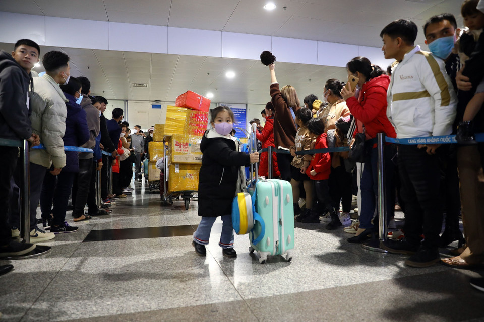 Một em nhỏ cùng gia đình trở về Việt Nam đón Tết Quý Mão. (Ảnh: Huy Hùng/TTXVN)