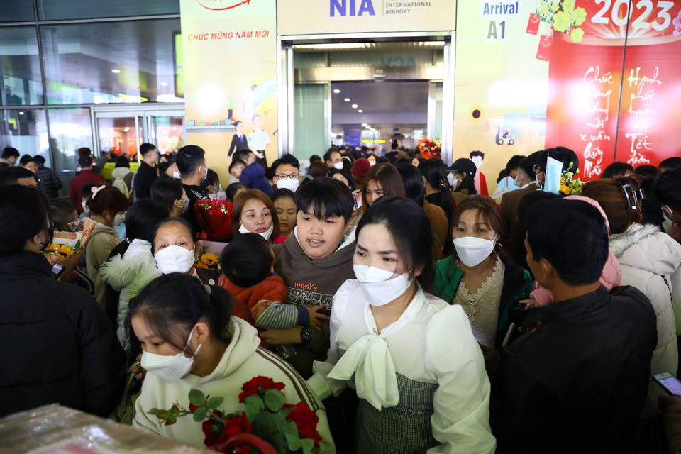 Một gia đình đón người từ nước ngoài trở về vất vả đẩy hành lý qua đám đông để ra xe ôtô. (Ảnh: Huy Hùng/TTXVN)