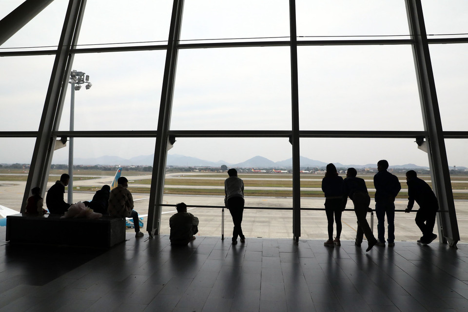 Người dân mong ngóng những chuyến bay hạ cánh để đón người thân từ nước ngoài trở về. (Ảnh: Huy Hùng/TTXVN)