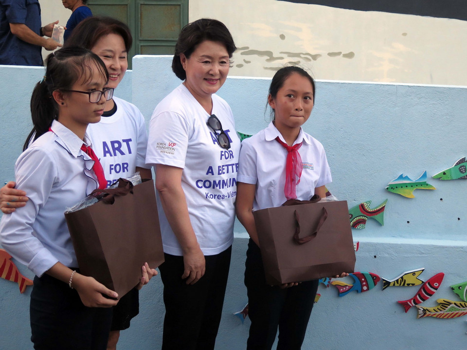 Phu nhân Kim Jung Sook tặng quà cho hai học sinh Trường Trung học cơ sở Thái Phiên, thành phố Tam Kỳ. (Ảnh: Đỗ Trưởng/TTXVN)