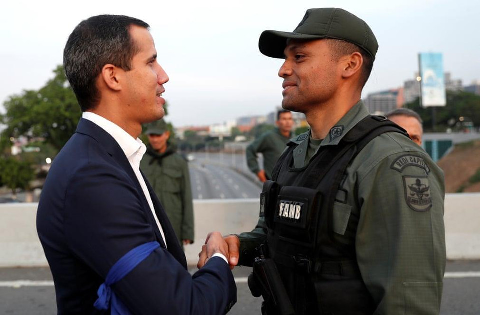 Ông Guaido bắt tay với một người lính ủng hộ mình. (Nguồn: Guardian)