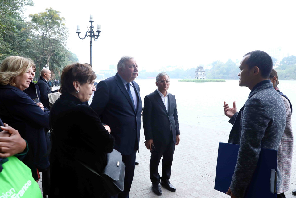 Chủ tịch Thượng viện Cộng hòa Pháp Gérard Larcher và các thành viên trong đoàn nghe giới thiệu về khu vực Hồ Hoàn Kiếm. (Ảnh: Phạm Kiên/TTXVN)