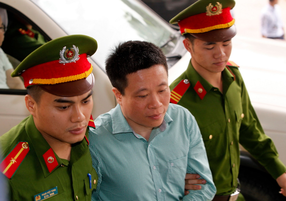 Cảnh sát dẫn giải bị cáo Hà Văn Thắm, cựu Chủ tịch Hội đồng quản trị Ngân hàng Thương mại cổ phần Đại Dương (Oceanbank) tới tòa. (Ảnh: Văn Điệp/TTXVN)
