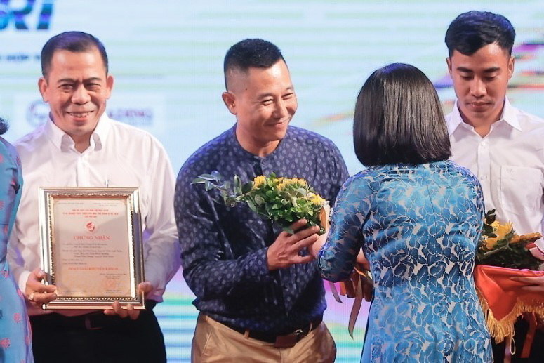 Ban tổ chức trao giải Khuyến khích cho nhóm tác giả Phan Nhật Anh, Lê Thanh Tùng và Lương Tuấn Đức thuộc Ban biên tập Ảnh, TTXVN. (Ảnh: Minh Quyết/TTXVN)