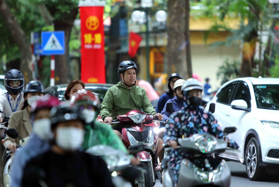 Gió mùa về kèm mưa nhỏ khiến nhiều người dân phải mặc thêm áo khoác vào sáng 10/10. (Ảnh: An Đăng/TTXVN)