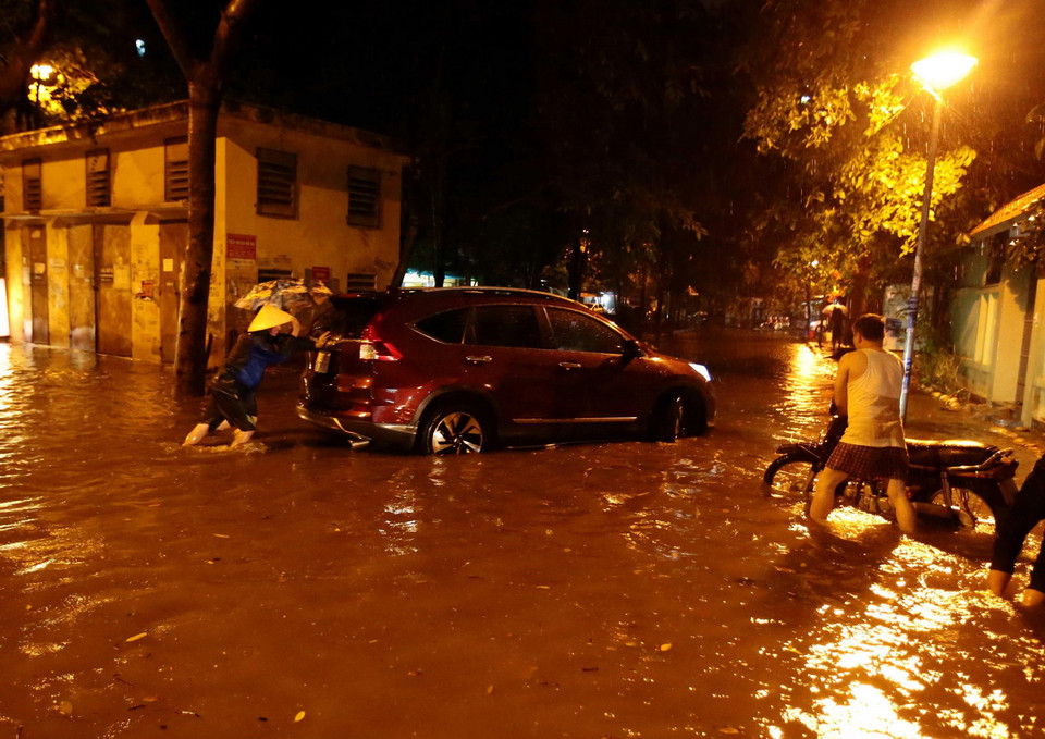 Rất nhiều ôtô và xe máy bị chết máy do đi qua đoạn đường ngập sâu. (Ảnh: Phạm Kiên/TTXVN)