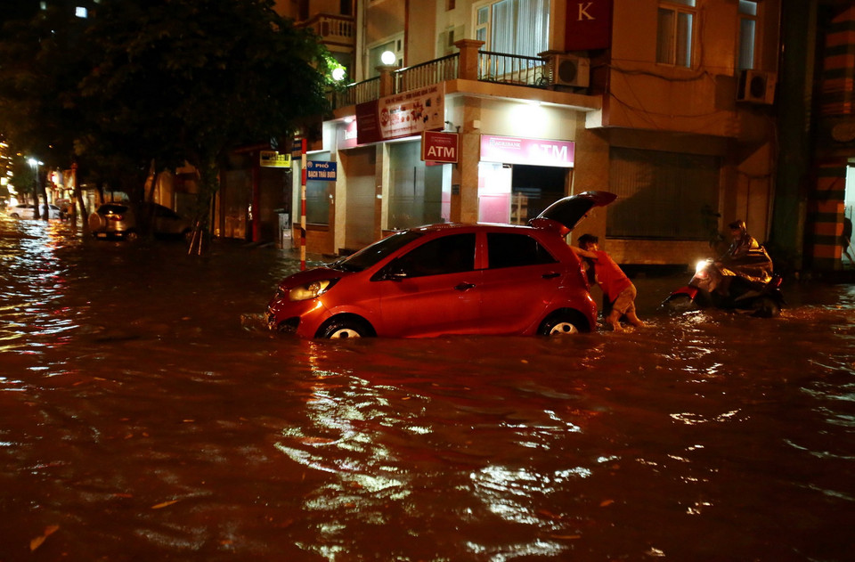 Rất nhiều ôtô và xe máy bị chết máy do đi qua đoạn đường ngập sâu. (Ảnh: Phạm Kiên/TTXVN)