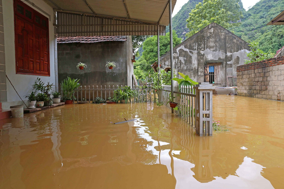 Nước sông Thương từ thượng nguồn đổ về nhanh cộng với nước từ trên núi đá cao tràn xuống làm nhiều nhà dân ở thị trấn Đồng Mỏ, huyện Chi Lăng. (Ảnh: Phạm Hậu/TTXVN)