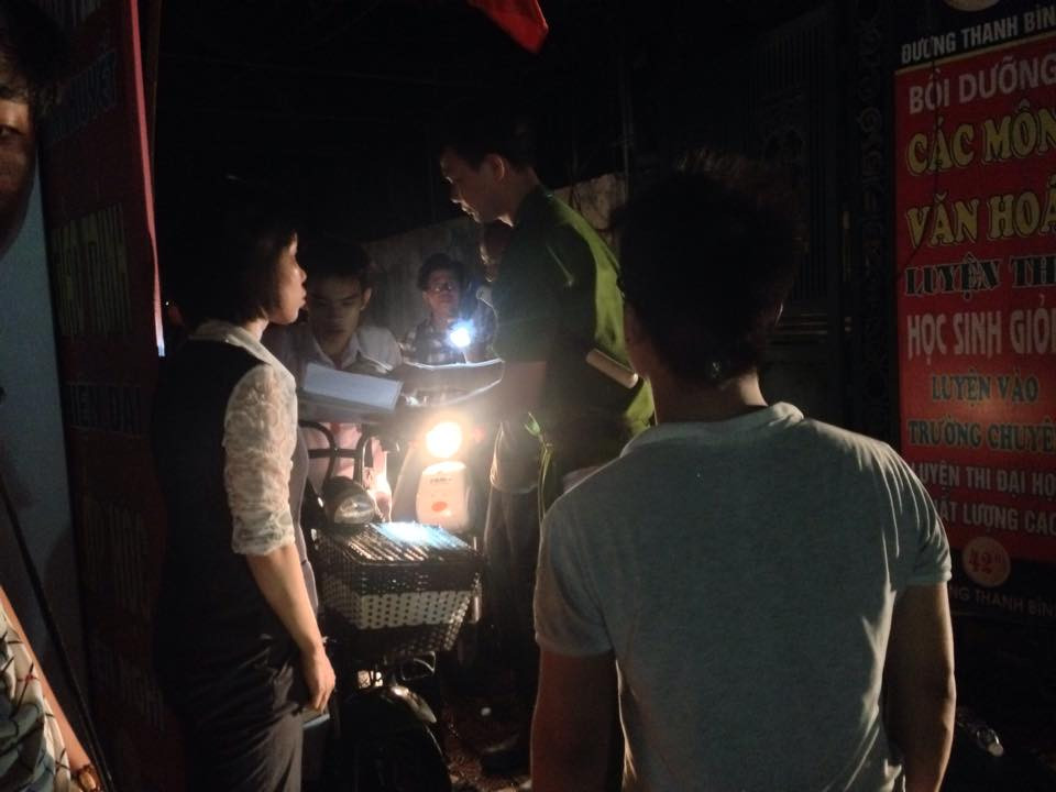 Cảnh sát đưa xe đạp điện của học sinh ra ngoài đám cháy. (Ảnh: PV/Vietnam+)