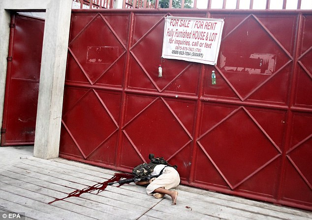 Một vệ sỹ khác nằm bên vũng máu. (Nguồn: Daily Mail)