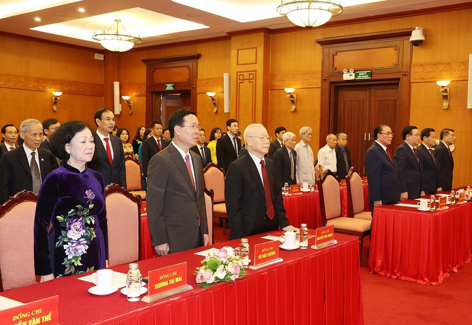 Các đồng chí lãnh đạo và nguyên lãnh đạo Đảng, Nhà nước thực hiện nghi lễ chào cờ. (Ảnh: Trí Dũng/TTXVN)