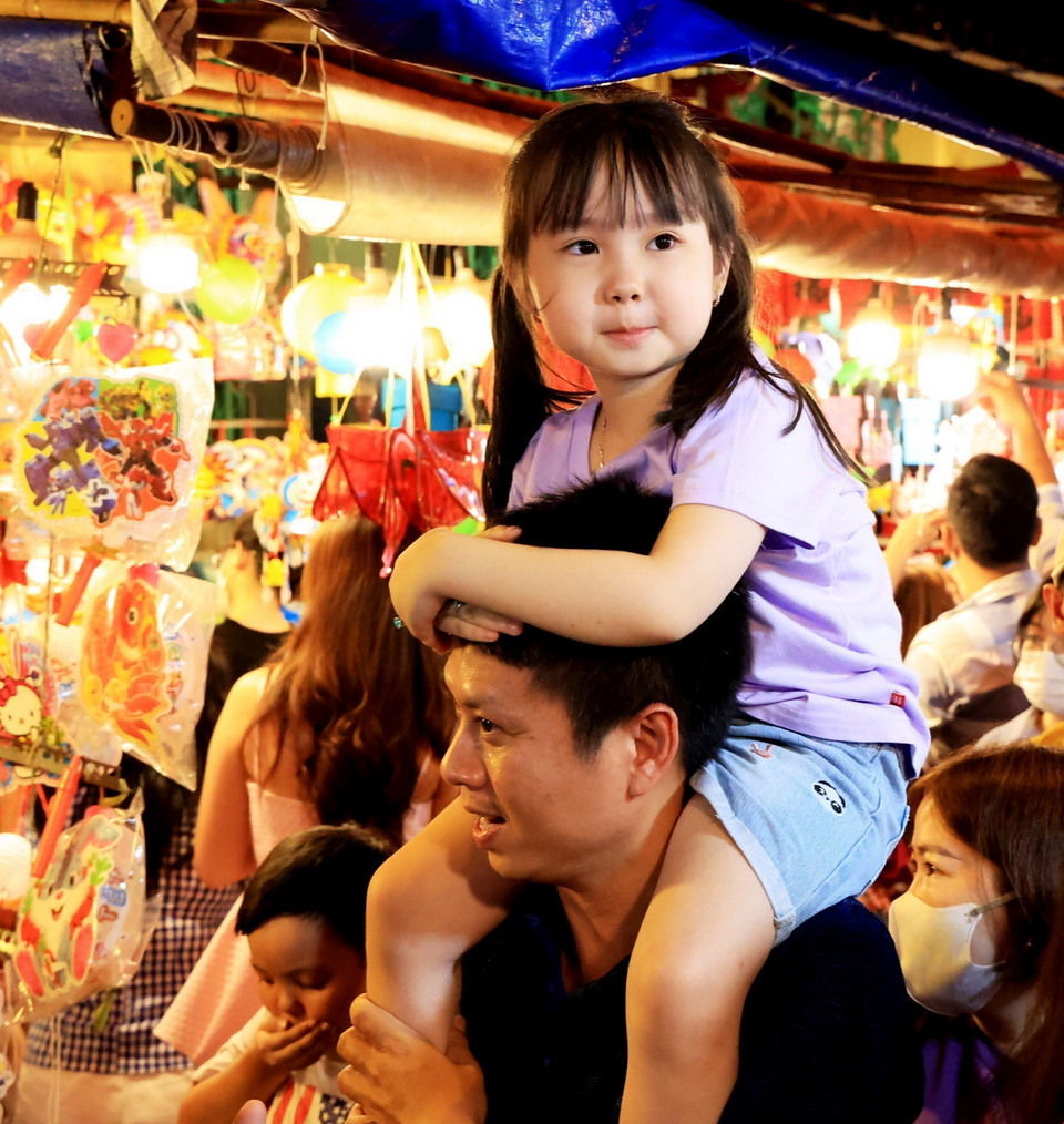 Em nhỏ được phụ huynh đưa đi chơi Phố lồng đèn Lương Nhữ Học. (Ảnh: Hồng Đạt/TTXVN)