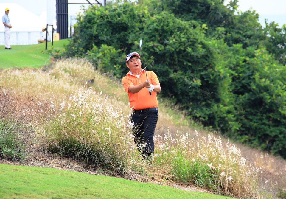 Một golf thủ khá vất vả khi bóng rơi vào hố cát. (Ảnh: Trần Long/Vietnam+)