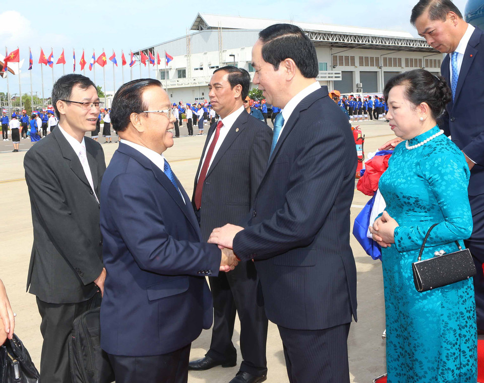 Đại diện Nhà nước Lào cùng cán bộ nhân viên Đại sứ quán Việt Nam và đông đảo kiều bào đón Chủ tịch nước Trần Đại Quang và phu nhân tại sân bay quốc tế Wattay. (Ảnh: Nhan Sáng/TTXVN)