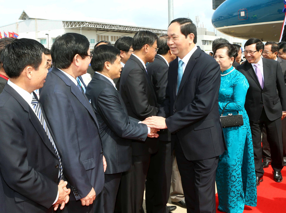 Đại diện Nhà nước Lào cùng cán bộ nhân viên Đại sứ quán Việt Nam và đông đảo kiều bào đón Chủ tịch nước Trần Đại Quang và phu nhân tại sân bay quốc tế Wattay. (Ảnh: Nhan Sáng/TTXVN)