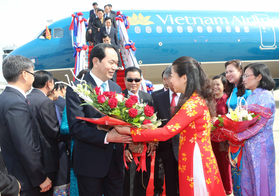 Đại diện Nhà nước Lào cùng cán bộ nhân viên Đại sứ quán Việt Nam và đông đảo kiều bào đón Chủ tịch nước Trần Đại Quang và phu nhân tại sân bay quốc tế Wattay. (Ảnh: Nhan Sáng/TTXVN)