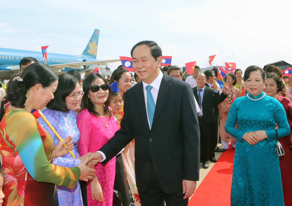 Đại diện Nhà nước Lào cùng cán bộ nhân viên Đại sứ quán Việt Nam và đông đảo kiều bào đón Chủ tịch nước Trần Đại Quang và phu nhân tại sân bay quốc tế Wattay. (Ảnh: Nhan Sáng/TTXVN)