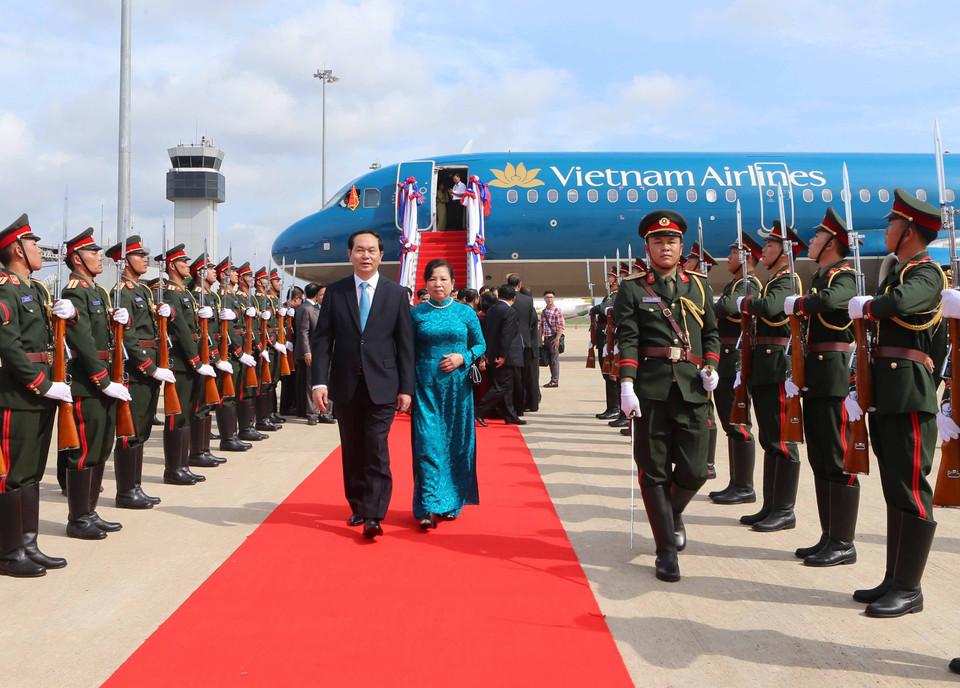 Đại diện Nhà nước Lào cùng cán bộ nhân viên Đại sứ quán Việt Nam và đông đảo kiều bào đón Chủ tịch nước Trần Đại Quang và phu nhân tại sân bay quốc tế Wattay. (Ảnh: Nhan Sáng/TTXVN)