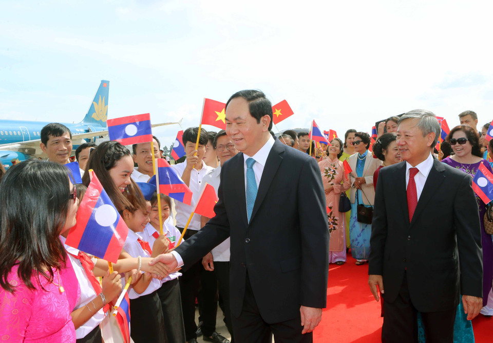 Đại diện Nhà nước Lào cùng cán bộ nhân viên Đại sứ quán Việt Nam và đông đảo kiều bào đón Chủ tịch nước Trần Đại Quang và phu nhân tại sân bay quốc tế Wattay. (Ảnh: Nhan Sáng/TTXVN)