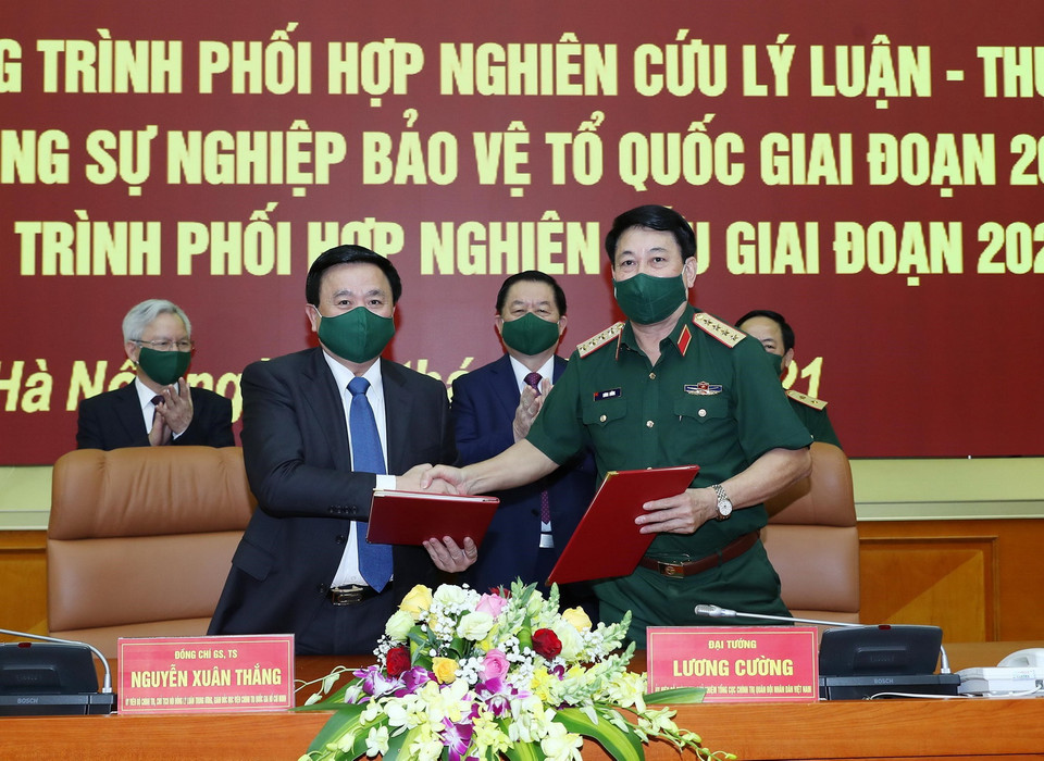  Đại tướng Lương Cường và ông Nguyễn Xuân Thắng trao bản ký kết chương trình hợp tác. (Ảnh: Trọng Đức/TTXVN)