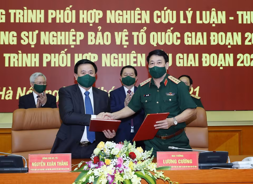  Đại tướng Lương Cường và ông Nguyễn Xuân Thắng trao bản ký kết chương trình hợp tác. (Ảnh: Trọng Đức/TTXVN)