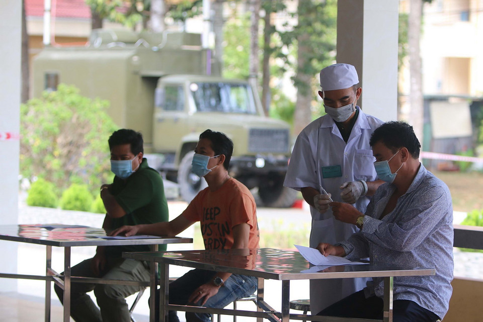 Lực lượng y bác sỹ Bệnh viện Quân dân y Miền Đông, Bệnh viện Quân y 7A, 7B kiểm tra thân nhiệt lần thức 2 các công dân có triệu chứng ho, sốt, khó thở trước khi đưa vào khu điều trị cách ly. (Ảnh: Thanh Vũ/TTXVN)