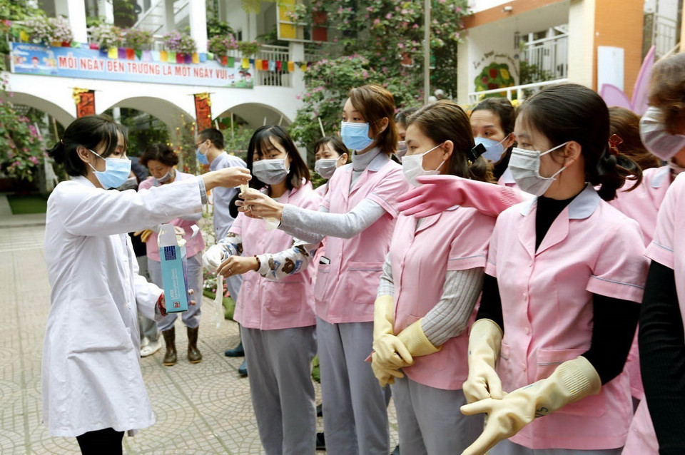 Nhân viên y tế quận Hai Bà Trưng (Hà Nội) hướng dẫn giáo viên, nhân viên các trường học vệ sinh môi trường phòng, chống dịch bệnh viêm đường hô hấp cấp do nCoV. (Ảnh: Dương Ngọc/TTXVN)