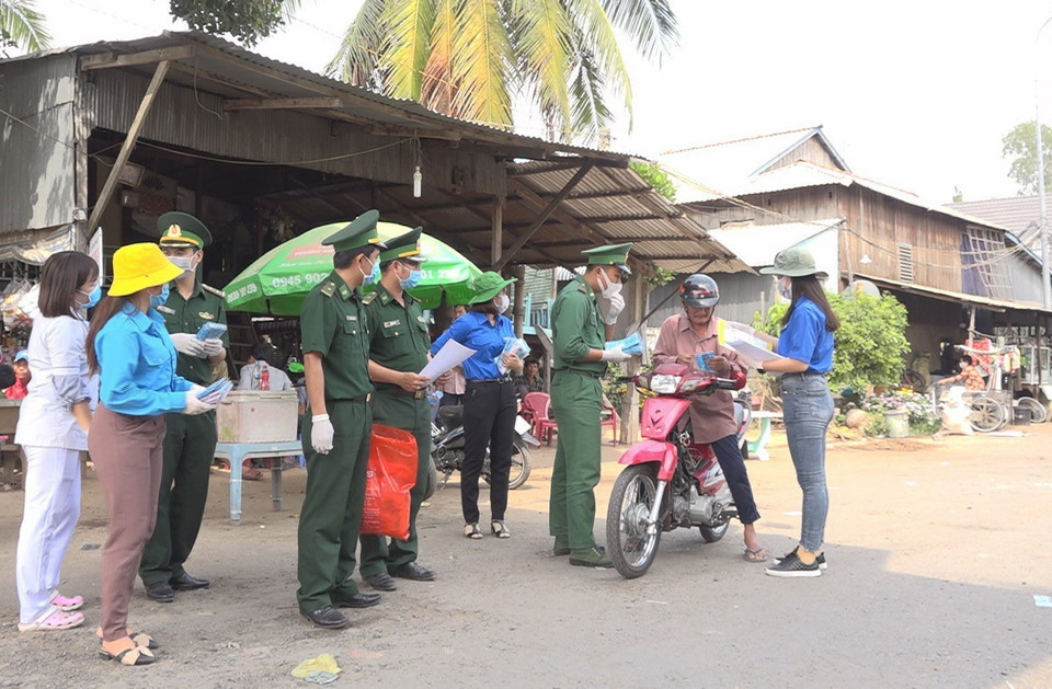 Bộ đội biên phòng Cửa khẩu Quốc tế Thường Phước (Đồng Tháp) cùng Đoàn viên thanh niên phát khẩu trang y tế miễn phí và hỗ trợ người dân những thông tin về diễn biến dịch bệnh. (Ảnh: Chương Đài/TTXVN)