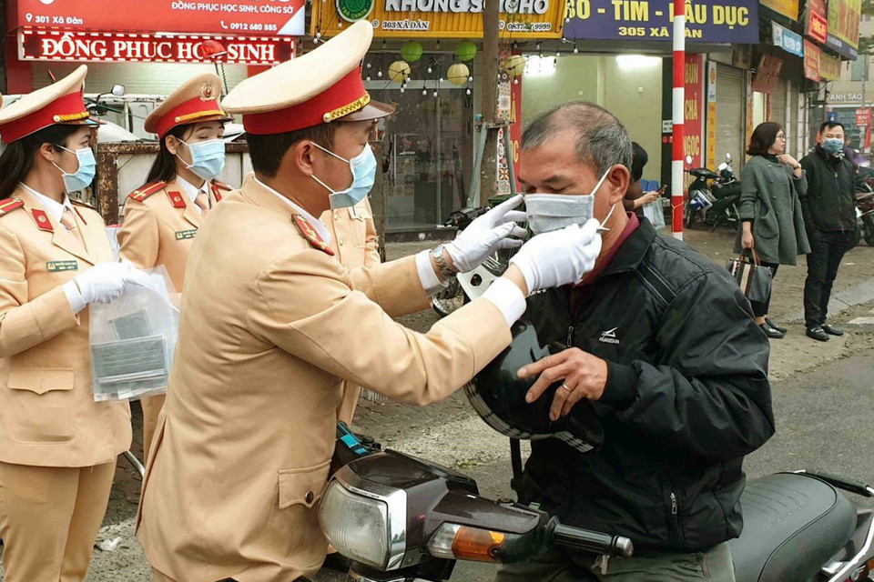 Cảnh sát giao thông Hà Nội phát khẩu trang miễn phí cho người dân tham gia giao thông để phòng chống dịch. (Ảnh: Doãn Tấn/TTXVN)
