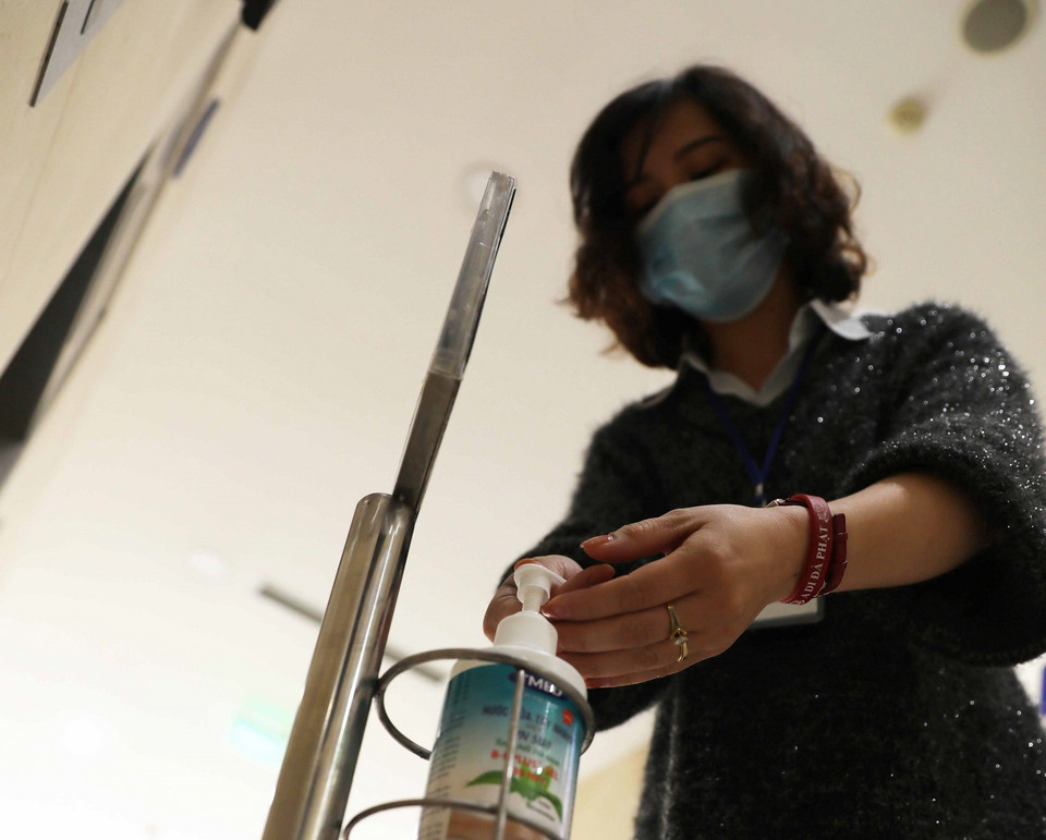 Cán bộ, nhân viên Thông tấn xã Việt Nam rửa tay bằng nước kháng khuẩn. (Ảnh: Lâm Khánh/TTXVN)