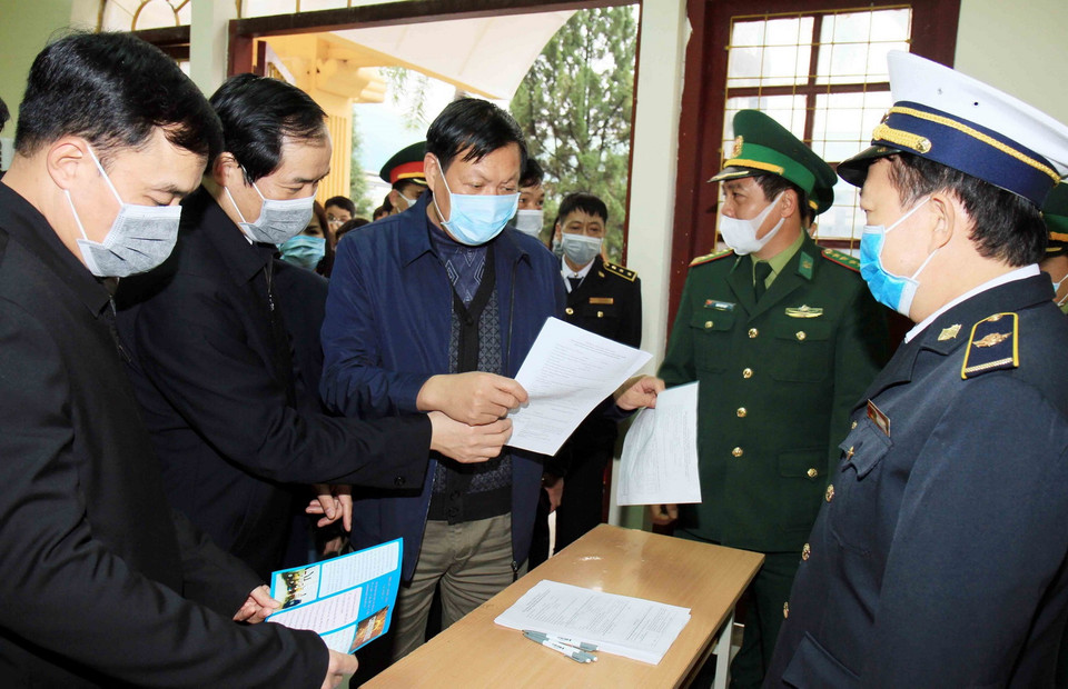 Thứ trưởng Bộ Y tế Đỗ Xuân Tuyên kiểm tra việc khai báo của khách nhập cảnh qua Cửa khẩu Quốc tế Hữu Nghị, tỉnh Lạng Sơn. (Ảnh: Thái Thuần/TTXVN)